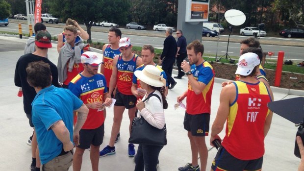 Gold Coast Suns players head to the 7-Eleven on Nielsens Road, set up as a search command centre, to join in the hunt for the missing girl.