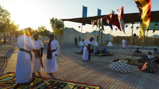 Omani performers prepare for a show for guests at a tent camp site.