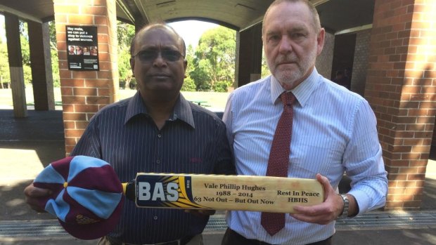 Phillip Hughes' year 12 coach Balan Balan and Homebush Boys principal Tim Jurd withthe schol cap and bat dedicated to their former pupil, Phillip Hughes.  