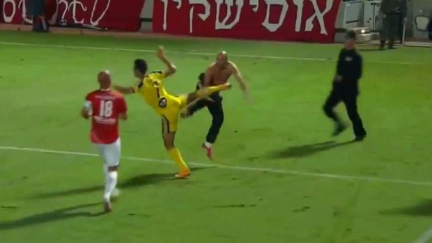 Flashpoint: The Hapoel supporter and Maccabi striker Eran Zahavi trade kicks.