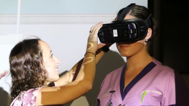 Nurse/midwife Jessica Williams, a lecturer and tutor in the school of nursing and midwifery at the University of Newcastle, using the Virtual Reality headset with Erin Bonett, a second-year bachelor of midwifery student at UOW.