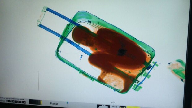 An X-ray image shows an 8-year-old boy hidden in a suitcase, in May 2015.
