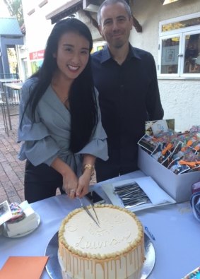 Orange Sky Laundry Canberra service manager Noreen Vu and volunteer Neil Stafford cut a cake celebrating 1300 washes.