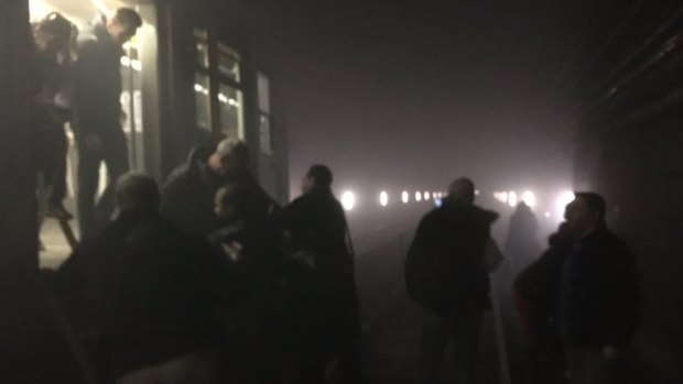 Passengers make their way off a train in the metro tunnel at Maalbeek station after the explosion.