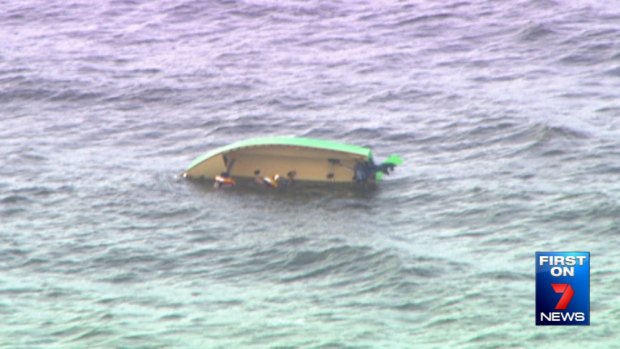 Two boaties cling to their capsized boat off Redcliffe.