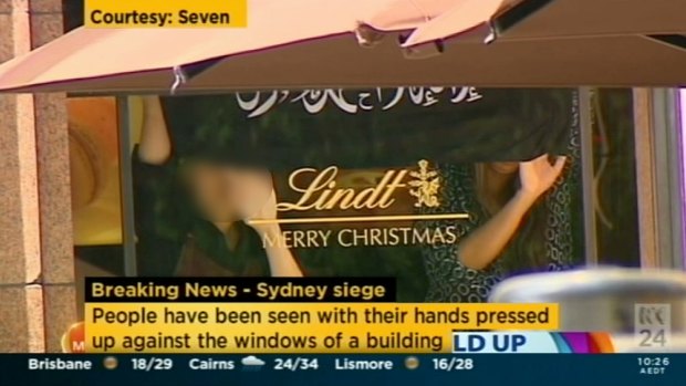 A screenshot from Channel Seven, showing hostages in the Lindt cafe