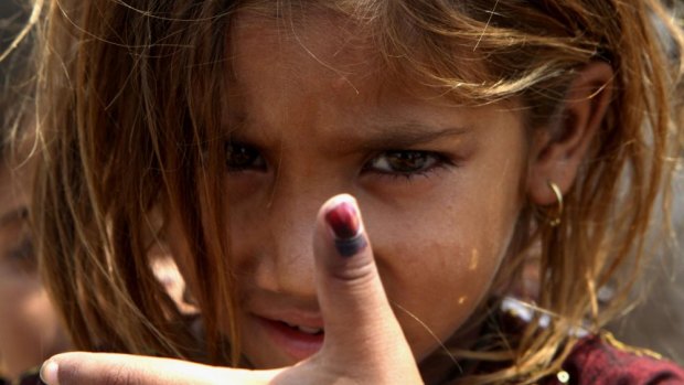 Pakistani girl Amina shows her thumb being marked after receiving polio vaccine in Lahore, Pakistan.