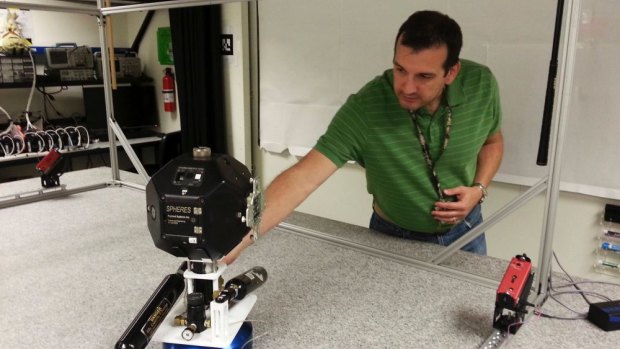 Smart SPHERES project manager Chris Provencher demonstrates one of Nasa's robots at the Ames Research Center in Mountain View, California.