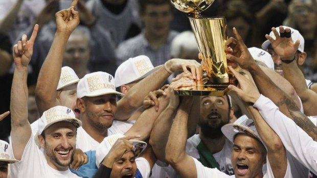 Undisputed champions: The Spurs celebrate with the trophy.