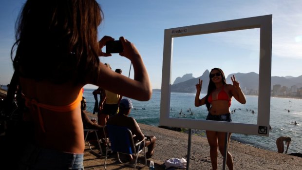 RESIZE: A beachgoer poses for a photo at a suggested Instagram spot on Ipanema Beach, Brazil.
