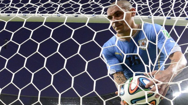 Uruguay's defender Maximiliano Pereira picks the ball out of the net after Marco Urena scored for Costa Rica in their Group D match.