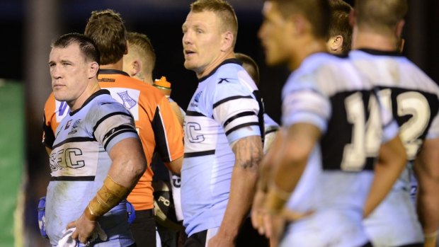 Cronulla skipper Paul Gallen looks dejected while standing with teammates in the in-goal area watching a Manly conversion at Remondis Stadium on Saturday night.
