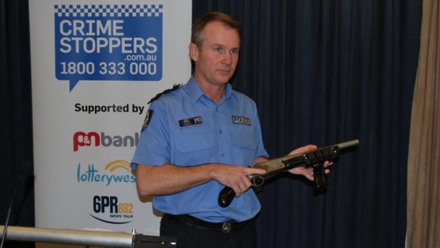 Acting State Crime Commander Scott Higgins with a shotgun, one of 61 firearms seized since January 1.