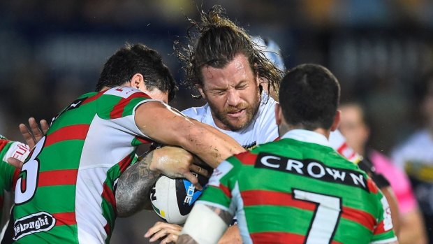 North Queensland veteran Ashton Sims is crunched by the South Sydney defence in Tonwsville.