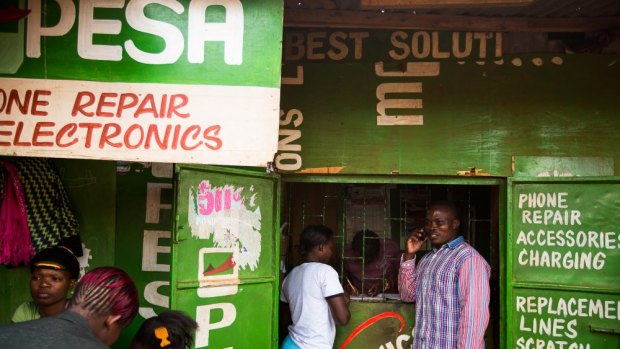 Mobile money: Residents transfer money using the M- Pesa banking service at a store in Nairobi, Kenya.