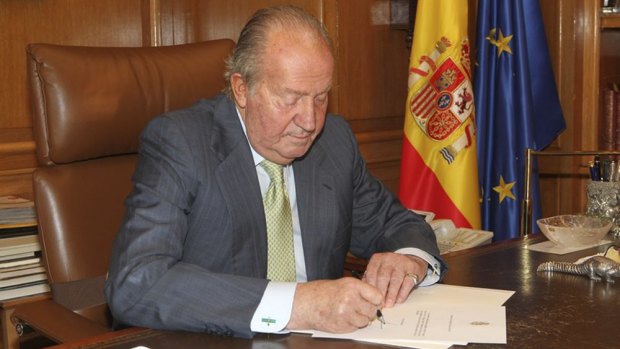 In this photo released by Spain's Royal Palace, King Juan Carlos signs a letter opening the way for his abdication.