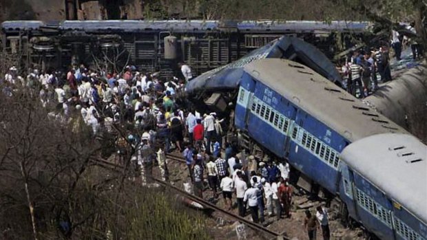 People gather around a passenger train that derailed near Roha station, 110 kilometres south of Mumbai.