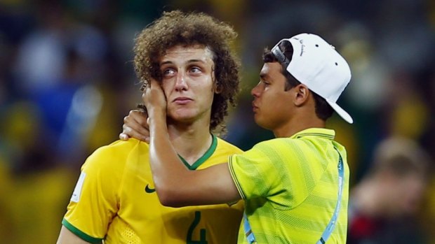 Stunned ... Brazil's stand-in captain David Luiz is consoled by teammate Thiago Silva after the 7-1 loss to Germany, which generated record-breaking social media activity.
