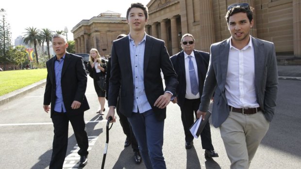 'My walking stick is a constant reminder of what I've lost': Liam Knight, centre, and supporters leave court on Friday.