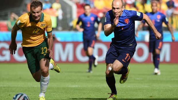 Socceroos defender Alex Wilkinson outpaces Dutch forward Arjen Robben to the ball during their clash in Porto Alegre.