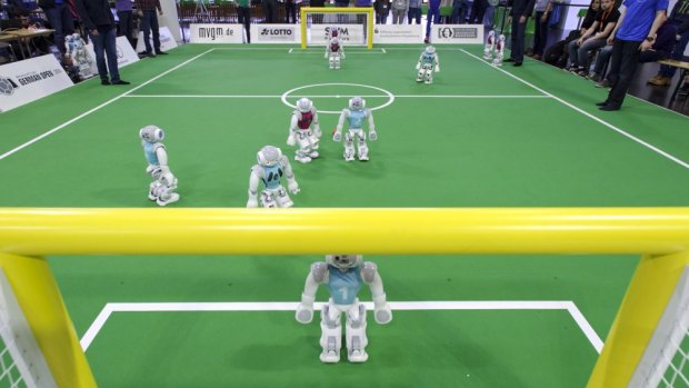 Two Nao robot teams play against each other in the 2014 RoboCup German Open in April.