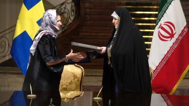 Sweden's feminist trade minister Ann Linde dons the hijab and wears a black cloak like her Iranian counterpart.