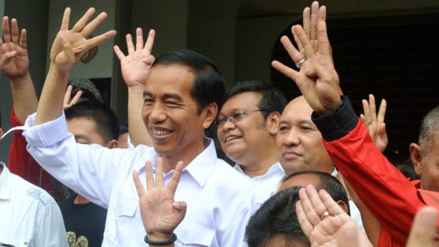 Joko Widodo holds up four fingers to depict his party's position on the ballot paper before the March election.