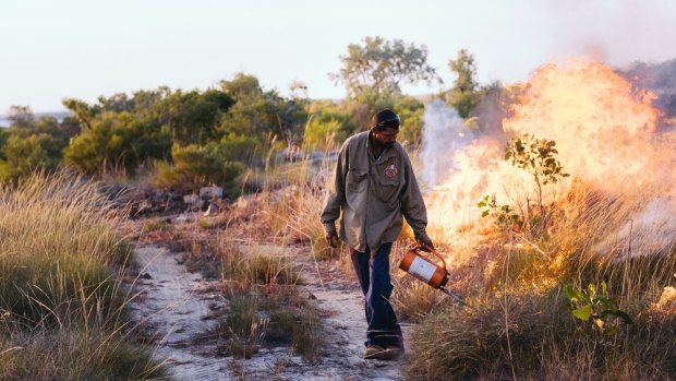 Uunguu ranger instituting 'right-way' fire - low intensity fires at the start of the dry season  which create a mosaic of burnt and unburnt areas to reduce the severity of subsequent lightning strike fires. 
