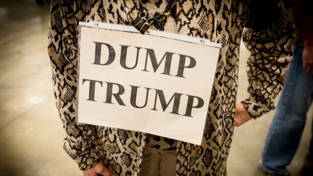 Jeannine Meeds of Mandeville, Louisiana, wears a "Dump Trump" sign during a town hall meeting.