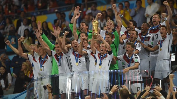 Germany's captain Philipp Lahm holds the trophy as the team celebrates winning its fourth World Cup.
