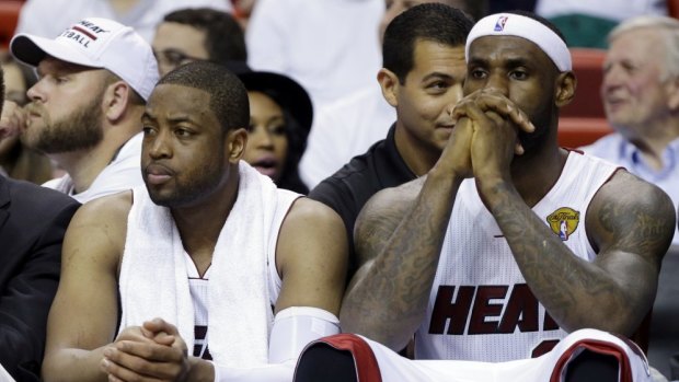 Once brothers: LeBron James and guard Dwyane Wade sit on the bench for Miami last season.