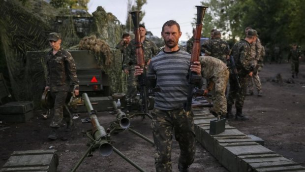 Ukrainian soldiers carry weapons seized from pro-Russian separatists near Slaviansk on Tuesday. 