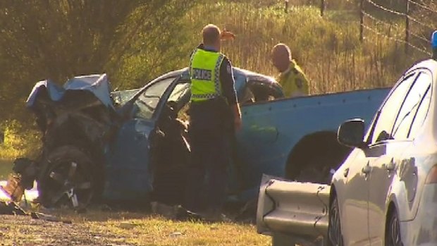 Police inspect the ute at the scene of the fatal crash.