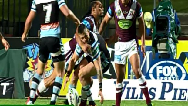 Charged: Manly's Martin Tapau tackles Cronulla's Jack Bird on Monday night.