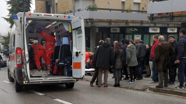 Paramedics attend to a wounded man after the shooting in Macerata, Italy.