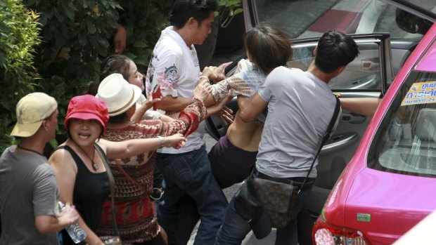 Crackdown: Plain-clothes police officers force a protester into a vehicle during an anti-coup demonstration in Bangkok on Sunday.
