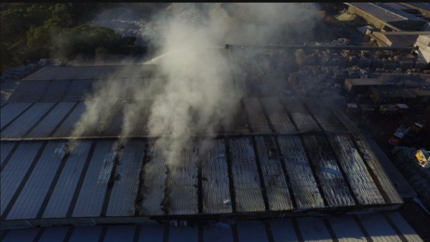 An aerial image of firefighters trying to control the Coolaroo blaze from a cage above the factory.