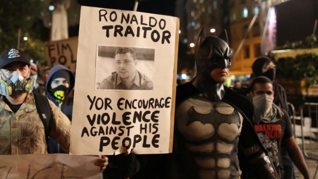 A demonstrator in a Batman costume carries a sign with a photo of former soccer player Ronaldo at a protest against the upcoming World Cup in Rio de Janeiro.
