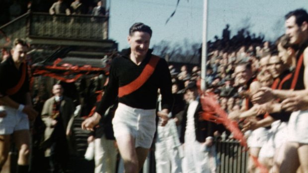 Essendon's Bill Hutchison runs through a guard of honour before the 1953 semi-final between Essendon and Footscray after winning the Brownlow Medal.