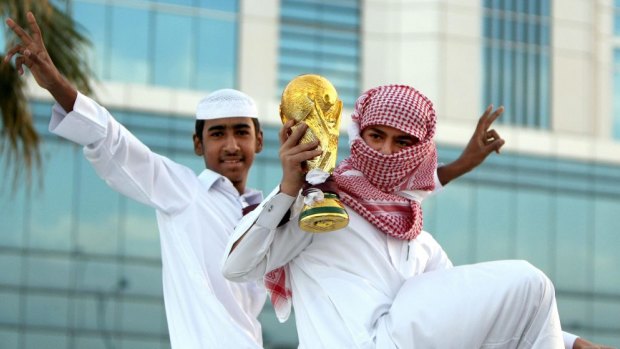 Qataris hold a mock World Cup trophy as they celebrate in Doha on December 3, 2010, a day after the world football's governing body FIFA announced that the tiny Gulf state will host the 2022 World Cup.