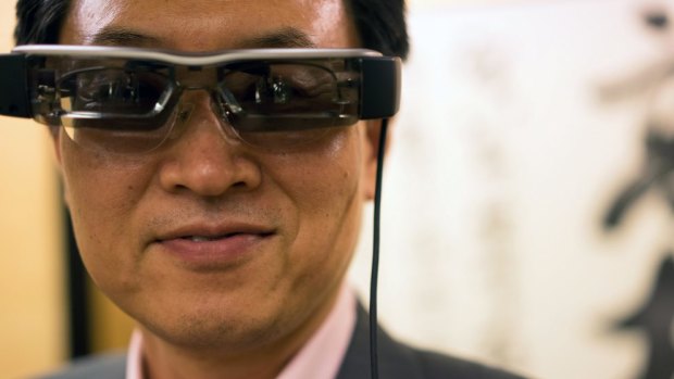 Epson president Minoru Usui models Epson's virtual reality glasses, based on its projector and sensing technology.