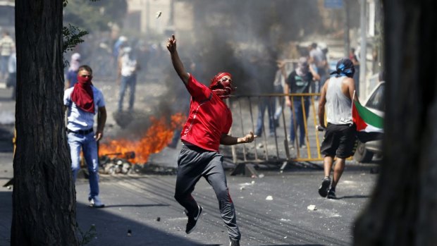 A Palestinian throws a stone during clashes with Israeli police after prayers on the first Friday of the holy month of Ramadan in East Jerusalem.