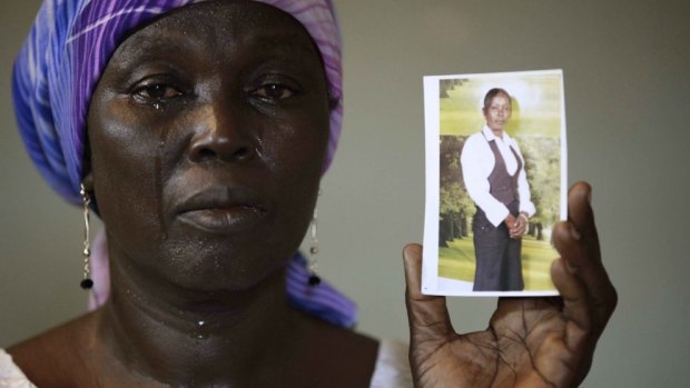 Martha Mark, the mother of kidnapped school girl Monica Mark, cries as she shows her photo in May 2014.