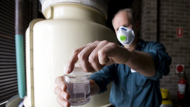 An environmental health officer tests a water cooler tower.