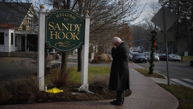 A man pauses to mourn at the entrance to the town of Sandy Hook on December 15, 2012, in the aftermath of the tragedy.
