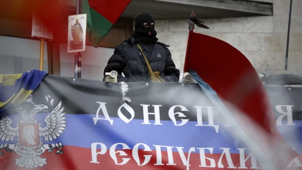 A masked pro-Russian activist on the balcony of the regional administration building  in Donetsk, Ukraine, in April 2014.