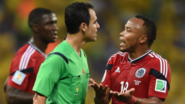 Not me sir ... Colombia's defender Juan Camilo Zuniga (righ) argues with Spanish referee Carlos Velasco Carballo after committing the foul on Neymar.