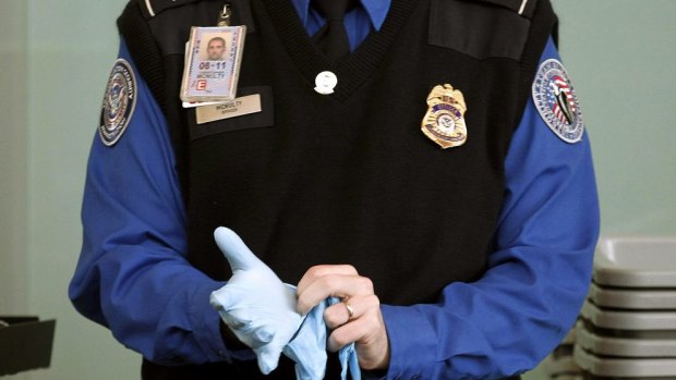 Charge your device prior travel or have it confiscated ... A Transportation Security Administration agent dons rubber gloves at a security checkpoint at Washington Reagan National Airport.