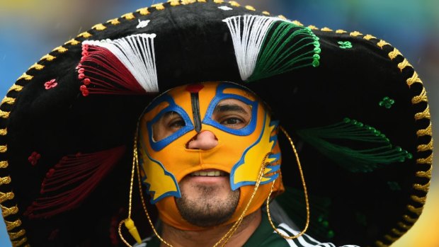 A Mexico fan looks on through the rain prior to the Group A match between Mexico and Cameroon at Estadio das Dunas in Natal.