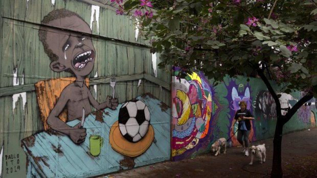 A mural by Brazilian street artist Paulo Ito, of a crying child who is served a soccer ball to appease his hunger, covers a portion of a school wall in Sao Paulo, Brazil, as part of a protest against the World Cup.